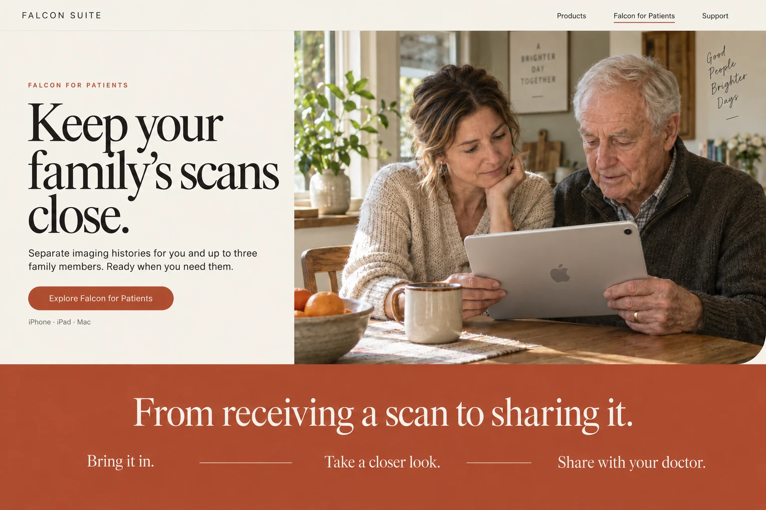 An adult daughter and her older father looking at an iPad together at a sunlit kitchen table.
